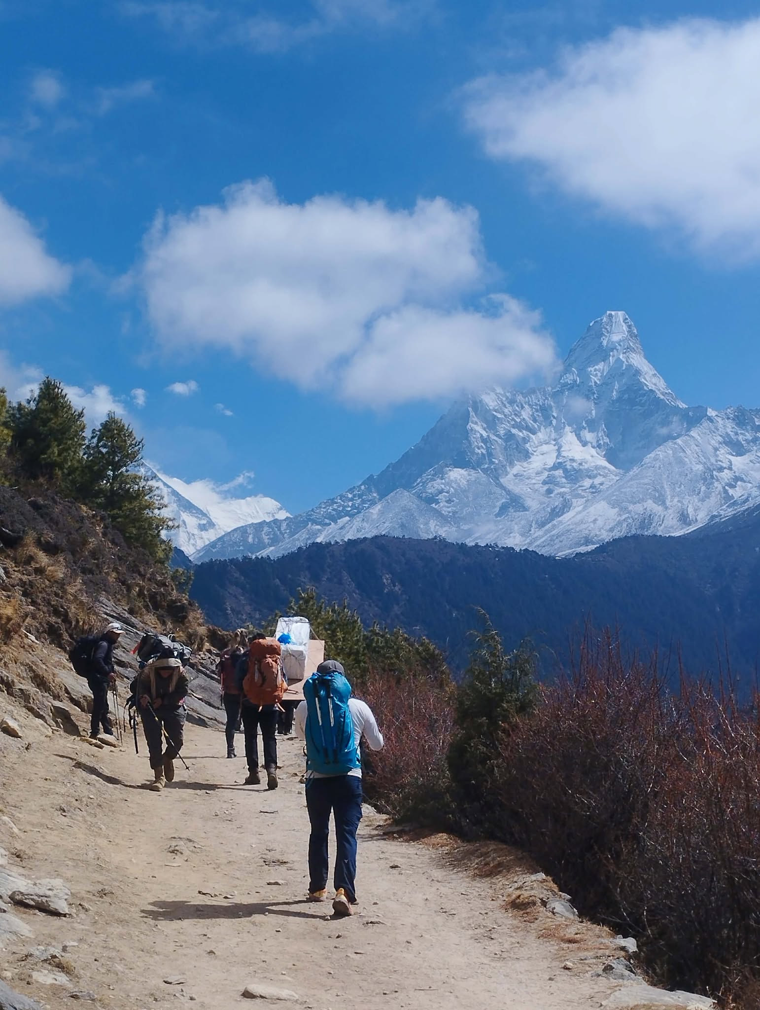 Group of trekkers hiking along the rocky trail toward Everest Base Camp in Nepal.