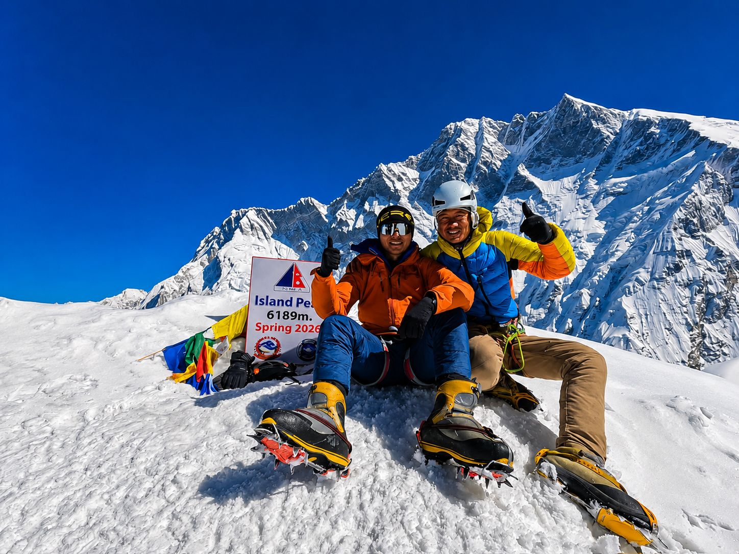 Climbers celebrating at the Island Peak (6,189 m) summit with snow-covered Himalayan peaks in Nepal.