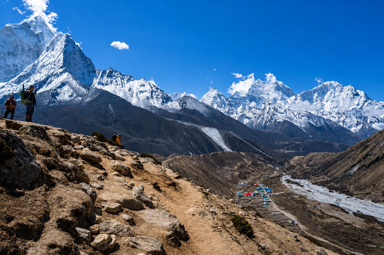 Trekkers on the Island Peak climbing trail overlooking the snow-covered Himalayan mountains and the Imja Valley in Nepal.