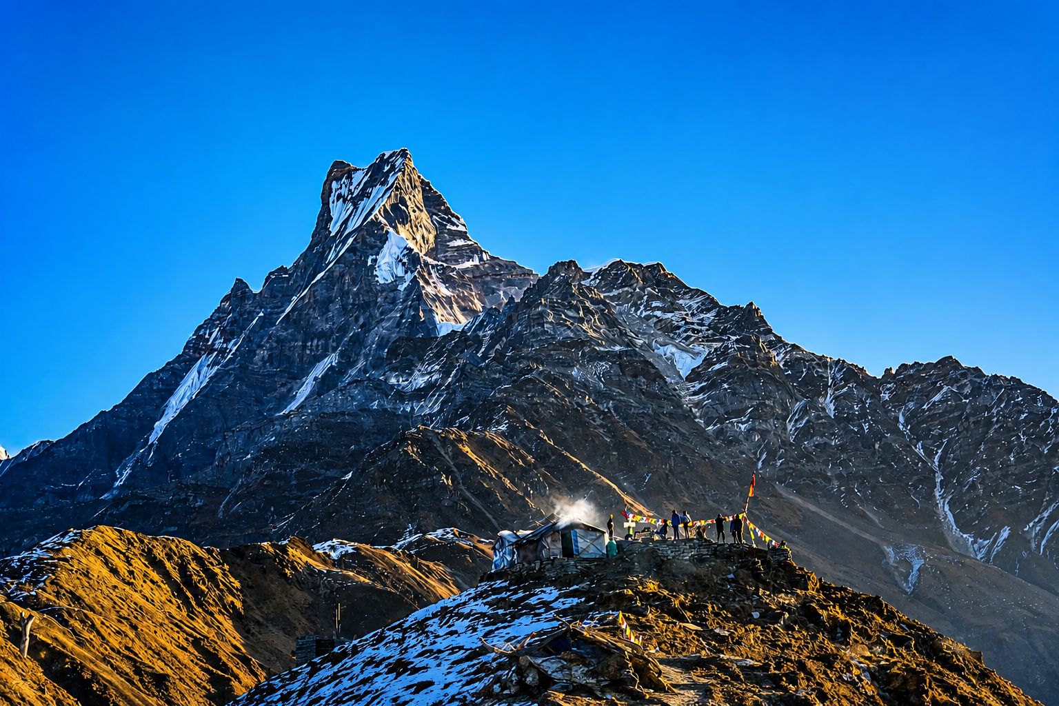 Machhapuchhre (Fishtail Mountain) towering above Mardi Himal High Camp with colorful prayer flags and Himalayan landscape in Nepal.