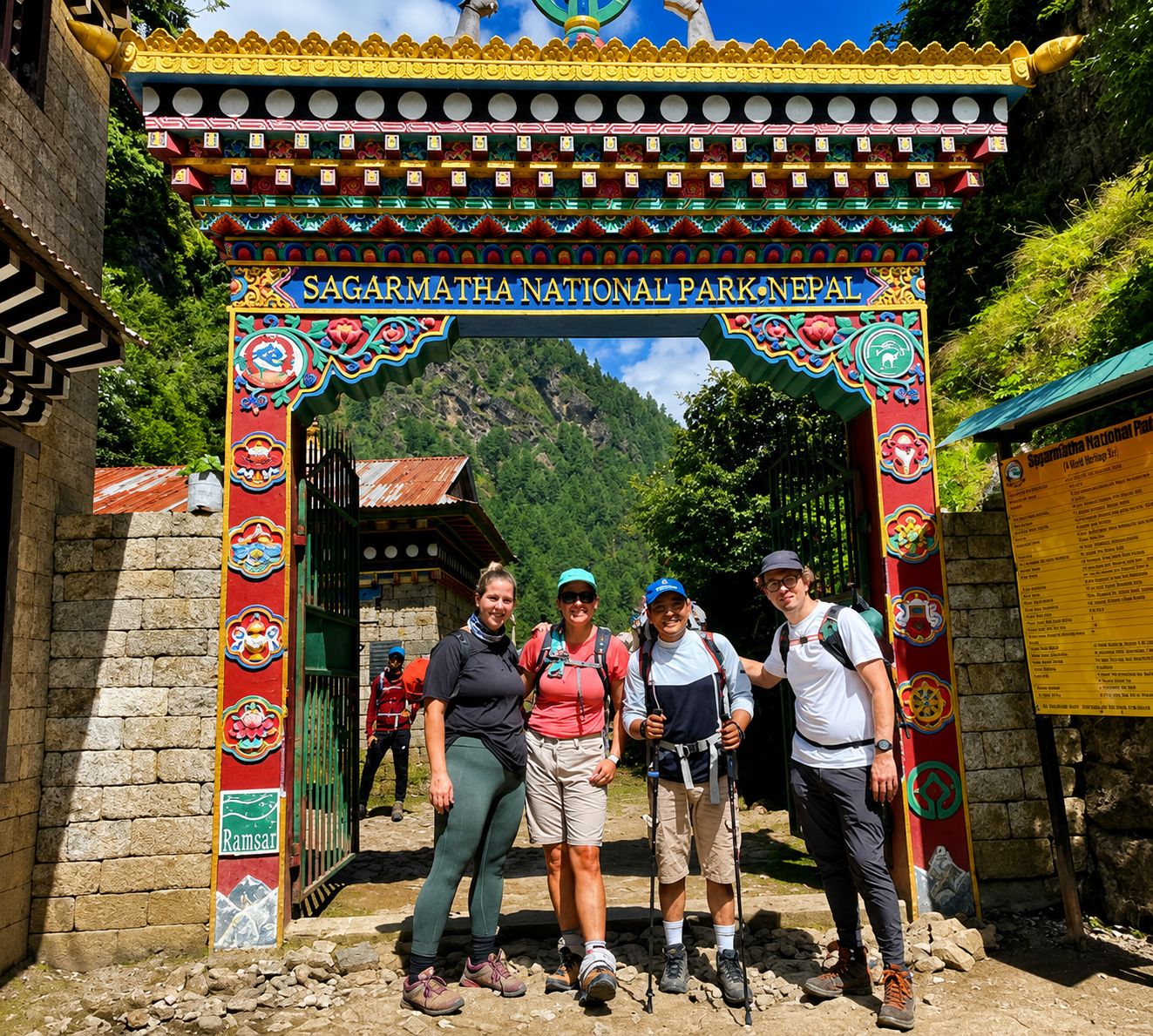 Trekkers posing beneath the colorful entrance gate of Sagarmatha National Park in Nepal.